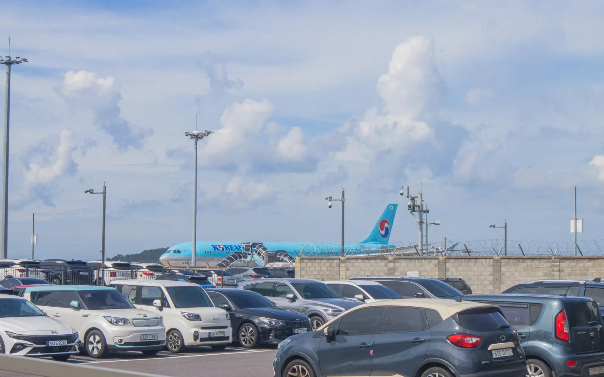 Geparkeerde auto's bij een luchthaven met een vliegtuig op de achtergrond